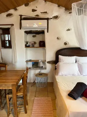 a bedroom with a bed and a wooden table at Caseddu di Chjarastella in Figari