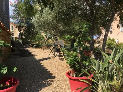 a garden with potted plants and a bench and trees at Caseddu di Chjarastella in Figari
