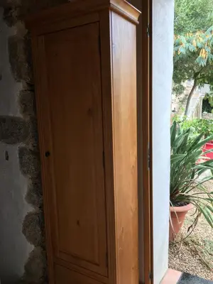 a wooden cabinet in a room with a plant at Caseddu di Chjarastella in Figari