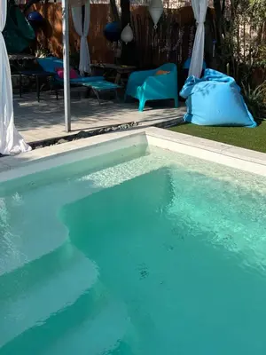 a swimming pool with blue water in a yard at Caseddu di Chjarastella in Figari