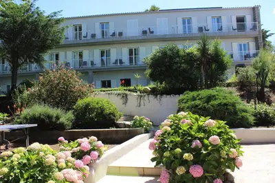 a large building with flowers in front of it at Hotel Arcu Di Sole in Propriano