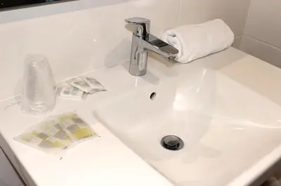 a bathroom sink with a faucet and a towel at Hotel Arcu Di Sole in Propriano