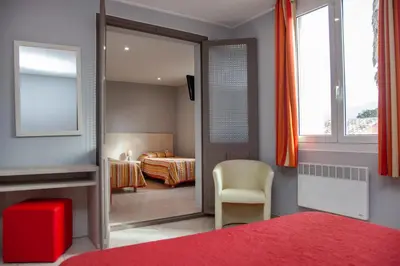 a room with a bedroom with a bed and a mirror at Hotel Arcu Di Sole in Propriano