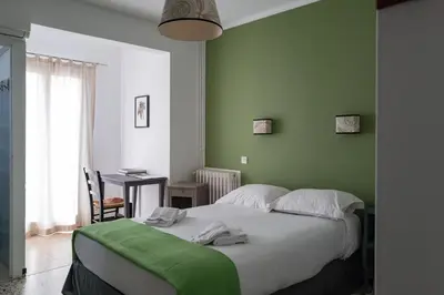 a bedroom with green walls and a bed with towels on it at Chez Marie in Linguizzetta