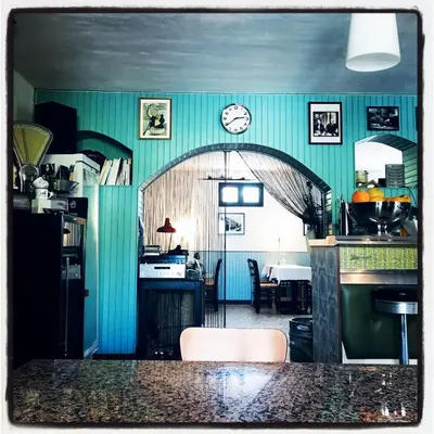 a kitchen with a table and a clock on the wall at Chez Marie in Linguizzetta