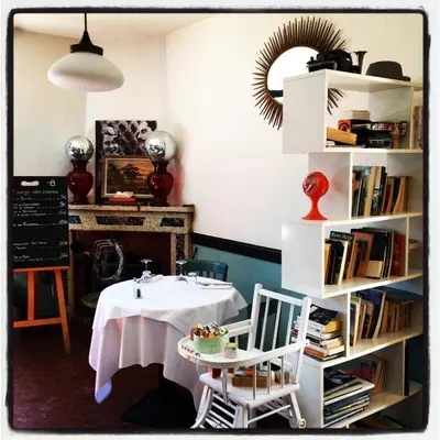 a room with a table and a shelf with books at Chez Marie in Linguizzetta