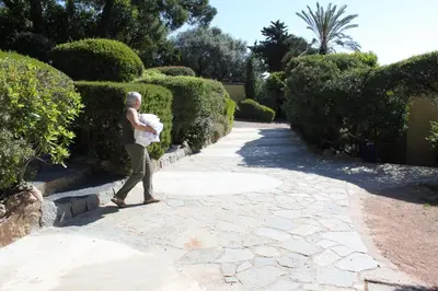 an older man walking down a path with a baby at Les Bungalows de Figha in Tarcu