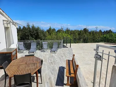 a patio with a table and chairs on a roof at Emma in Sari Solenzara