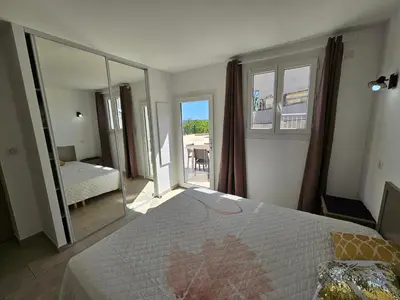 a bedroom with a bed and a view of a patio at Emma in Sari Solenzara