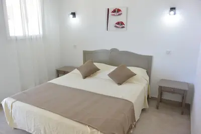 a bedroom with a large white bed with two pillows at Emma in Sari Solenzara