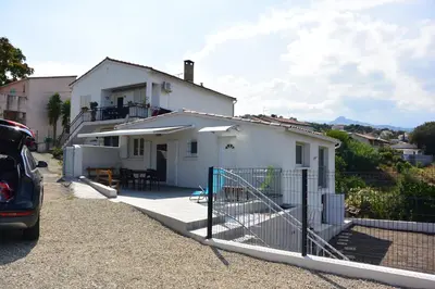 a white house with a fence in front of it at Emma in Sari Solenzara