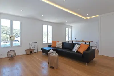 a living room with a black couch and a table at Superbe T3 sur la Marina de Bonifacio in Bonifacio