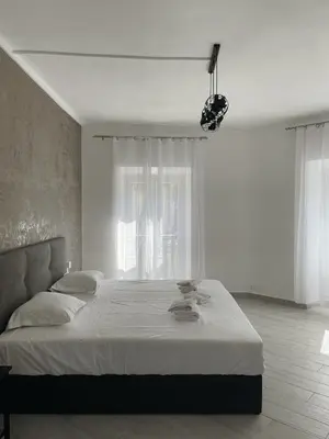 a bedroom with a large bed and a table at L'Escale chambres privées chez l'habitant JFDL in Bonifacio