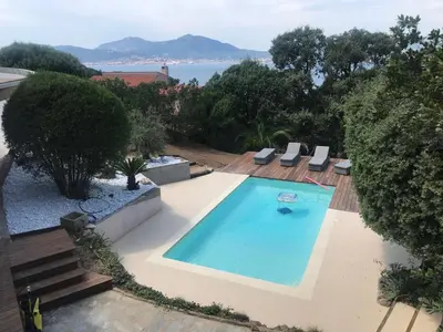 a swimming pool with a view of the water at Villa Vue Mer, piscine chauffée, tennis in Porticcio