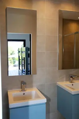 a bathroom with two sinks and a mirror at Villa Vue Mer, piscine chauffée, tennis in Porticcio