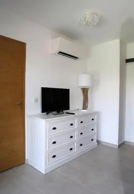 a white dresser with a television on top of it at Villa Vue Mer, piscine chauffée, tennis in Porticcio