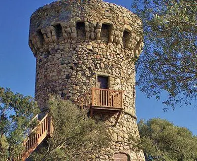 a stone tower with a balcony on top of it at Tour Génoise Micalona, Domaine de l'Oglisatru in Olmeto