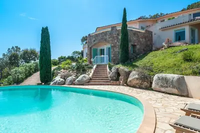 a large swimming pool in front of a house at La Veglia in Porto-Vecchio