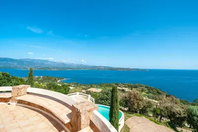 a swimming pool with a view of the water at La Veglia in Porto-Vecchio