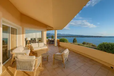 a patio with chairs and a view of the water at La Veglia in Porto-Vecchio