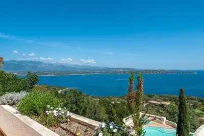 a view of a lake from a hill with flowers at La Veglia in Porto-Vecchio