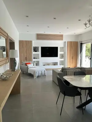 a living room with a couch and a tv on a wall at La villa Serena in Bonifacio