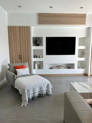 a living room with a couch and a flat screen tv at La villa Serena in Bonifacio