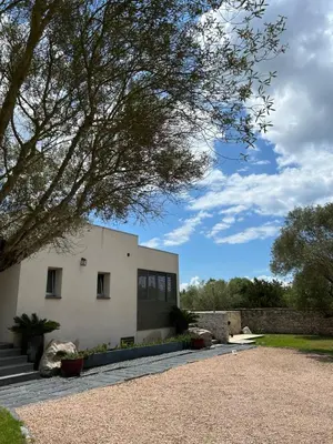 a white house with a tree in front of it at La villa Serena in Bonifacio