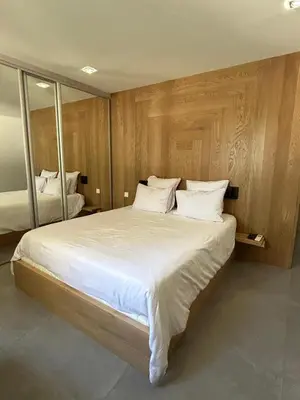 a bedroom with a large bed with white sheets and pillows at La villa Serena in Bonifacio