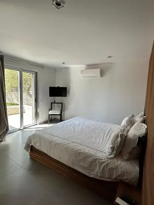 a bedroom with a bed in a room with a tv at La villa Serena in Bonifacio