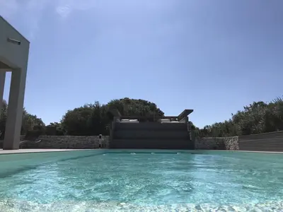 a swimming pool in front of a house at La villa Serena in Bonifacio