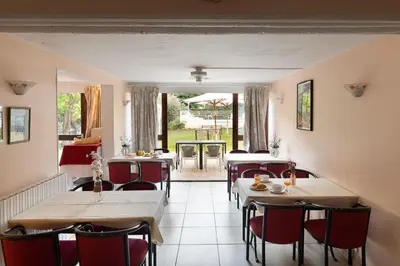 a restaurant with tables and chairs and a patio at Appart Hotel Corte HR in Corte