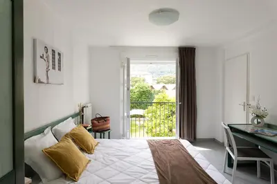 a bedroom with a bed and a desk and a window at Appart Hotel Corte HR in Corte