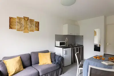 a living room with a couch and a kitchen at Appart Hotel Corte HR in Corte