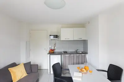 a kitchen and a living room with a table at Appart Hotel Corte HR in Corte