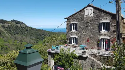 an old stone house with a green roof at English Club in Corsica A in Porri
