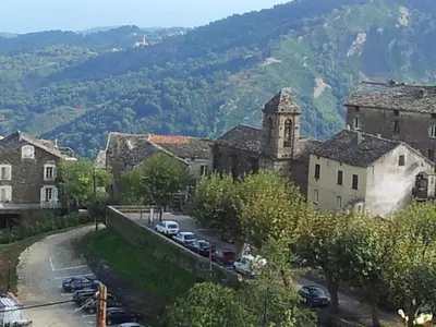 a town with cars parked in a parking lot at English Club in Corsica A in Porri