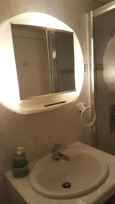 a bathroom sink with a medicine cabinet and a mirror at English Club in Corsica A in Porri