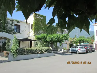 a building with cars parked in a parking lot at Hotel Costa Verde in Moriani Plage