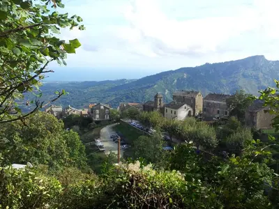 a view of a town with mountains in the background at English Club in Corsica B&B in Porri