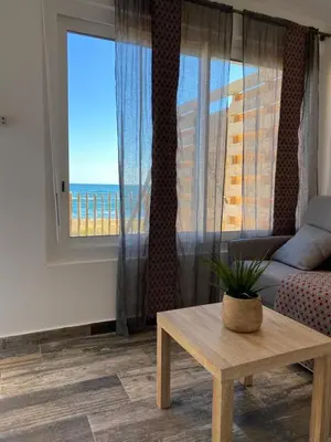 a living room with a table and a view of the ocean at Mariana Plage in La Marana