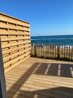 a wooden deck with the ocean in the background at Mariana Plage in La Marana