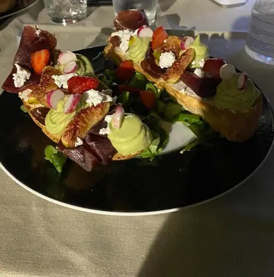 a plate of food with sandwiches and salad on a table at Mariana Plage in La Marana