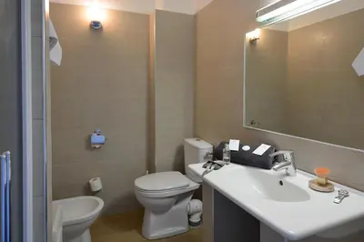 a bathroom with a sink and a toilet and a mirror at Hotel Les Eucalyptus in Porto Pollo