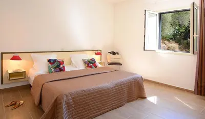 a bedroom with a large bed and a window at Hotel Les Eucalyptus in Porto Pollo