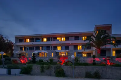a building with red lights in front of it at Hotel Les Eucalyptus in Porto Pollo
