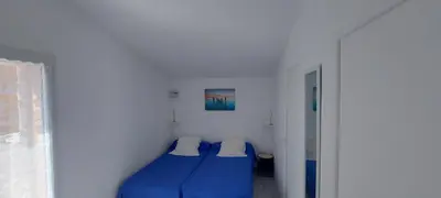 a bedroom with a blue bed and a window at Residence Riviera in Porto-Vecchio
