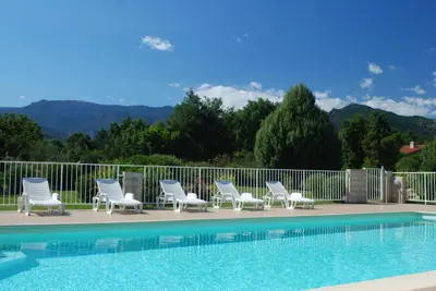 a row of lounge chairs next to a swimming pool at Residence Riviera in Porto-Vecchio