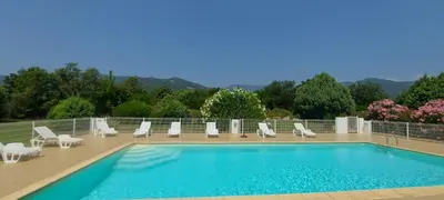 a garden with plants and rocks next to a swimming pool at Residence Riviera in Porto-Vecchio