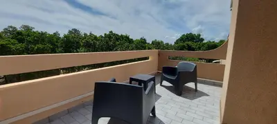 a balcony with two chairs and a view of trees at Residence Riviera in Porto-Vecchio